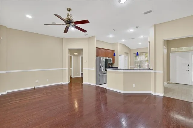 a kitchen with stainless steel appliances granite countertop a refrigerator a sink a stove and a refrigerator