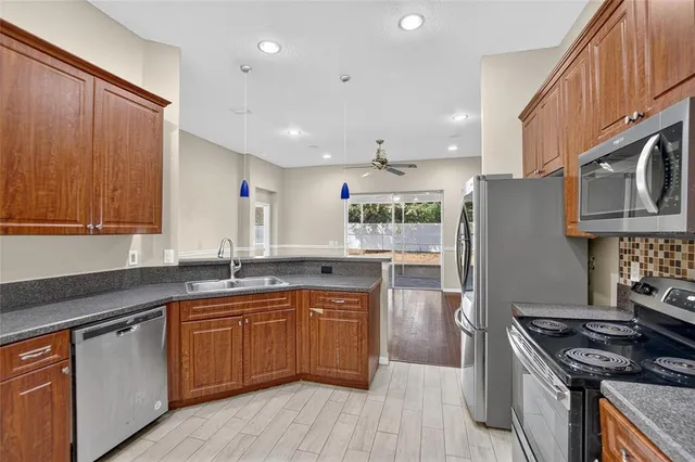a large kitchen with stainless steel appliances granite countertop a refrigerator and a sink