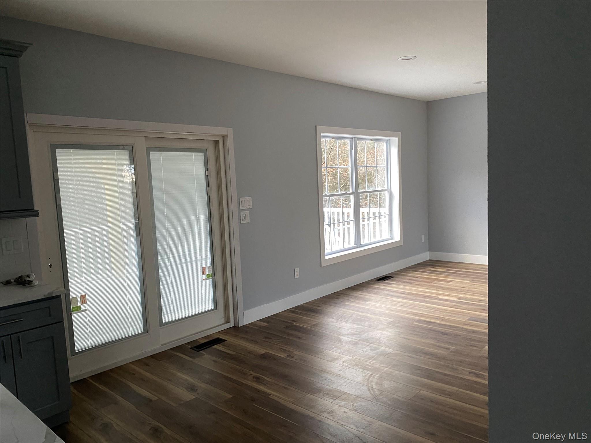44 Roslyn Ridge Road Smallwood, NY 12778 - Photo 7 of 24 an empty room with wooden floor and windows with curtains
