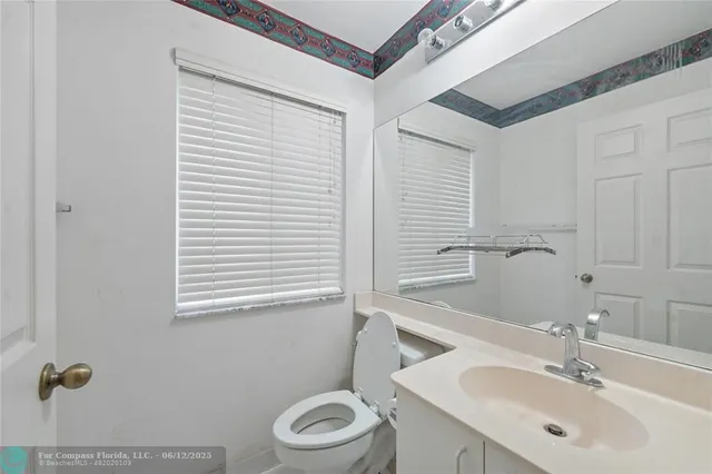a bathroom with a sink a toilet and mirror