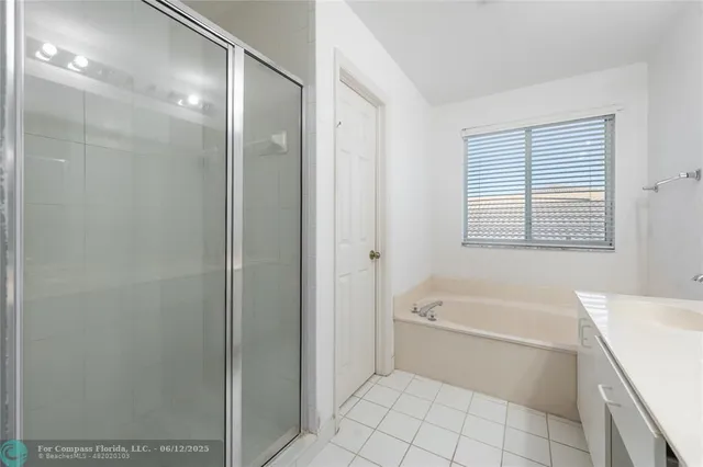 a bathroom with a tub shower and a sink