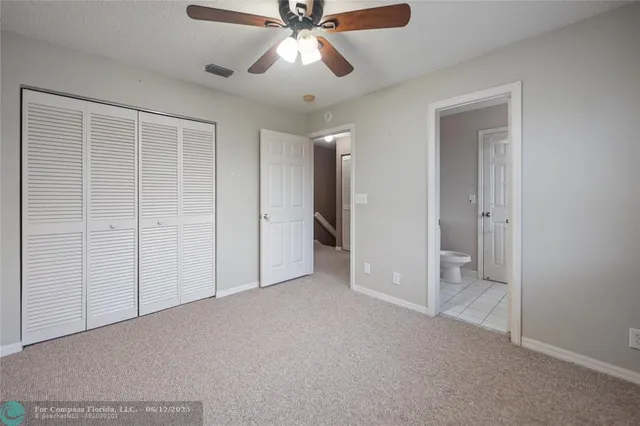 an empty room with closet and a ceiling fan