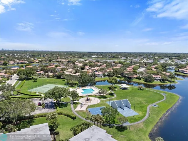 an aerial view of residential houses with outdoor space and lake view