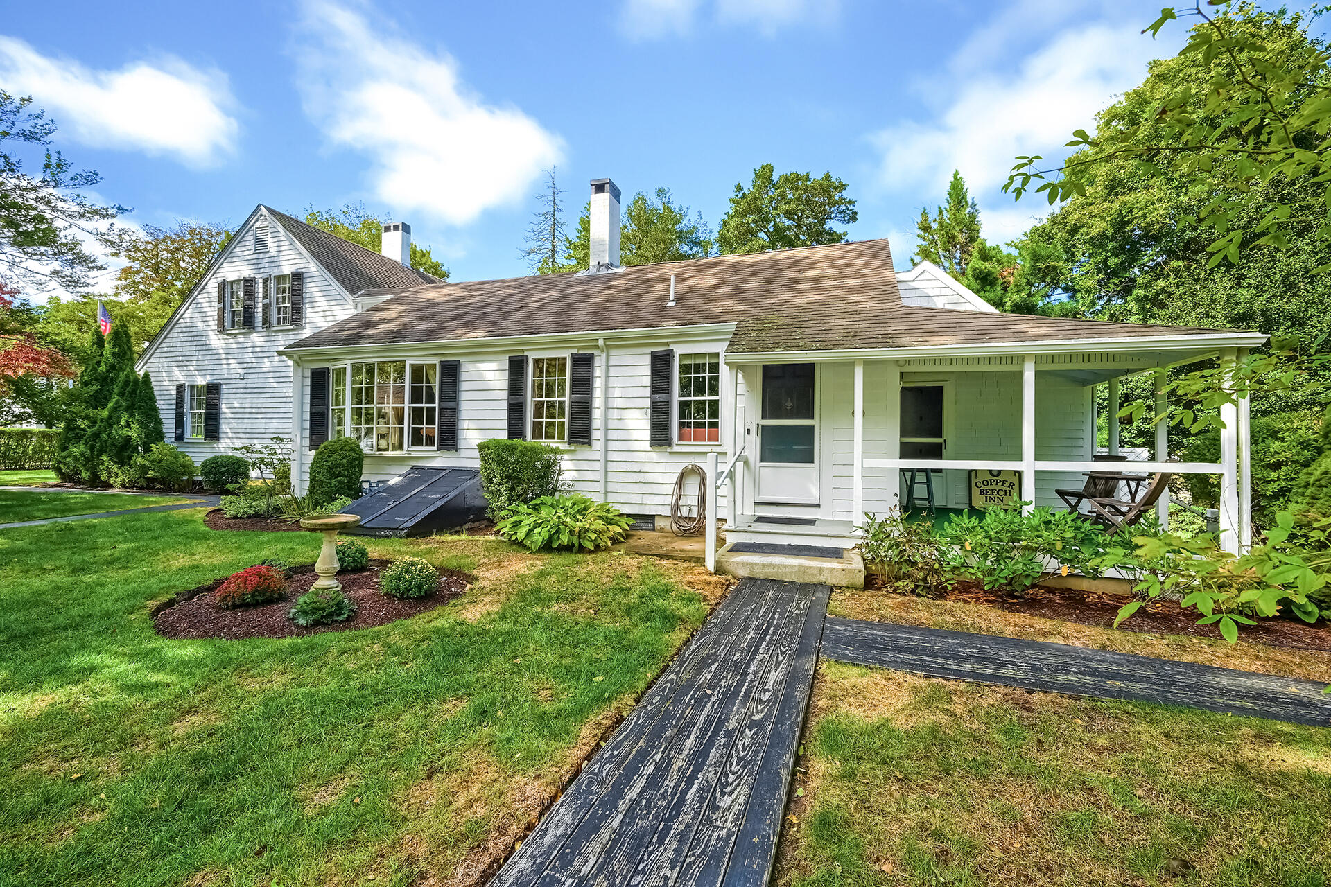 497 Main Street Centerville, MA 02632 - Photo 3 of 50 a front view of a house with a yard table and chairs