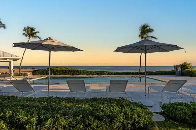 a living room with furniture kitchen view and a large window