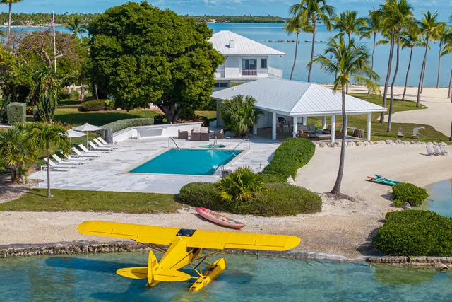 a view of a backyard with lawn chairs plants and wooden fence