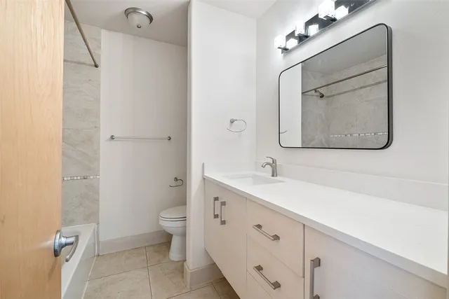 a bathroom with a double vanity sink mirror and toilet