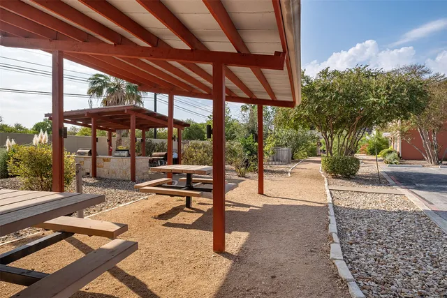 a view of a patio with a table and chairs under an umbrella with a patio