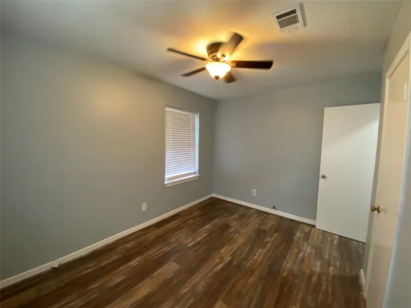 a view of a hallway with wooden floor and entryway