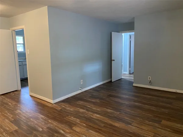 an empty room with wooden floor and entrance
