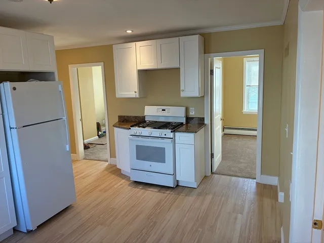 a kitchen with a refrigerator sink and cabinets