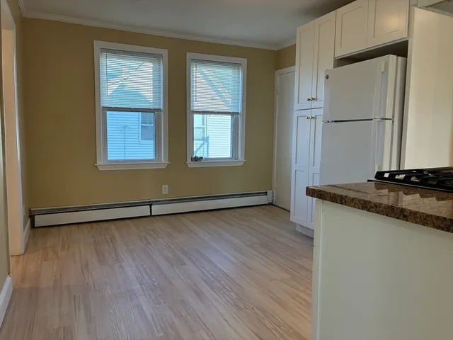 a view of a kitchen with wooden floor and electronic appliances