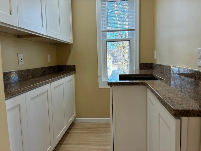 a kitchen with granite countertop cabinets and window