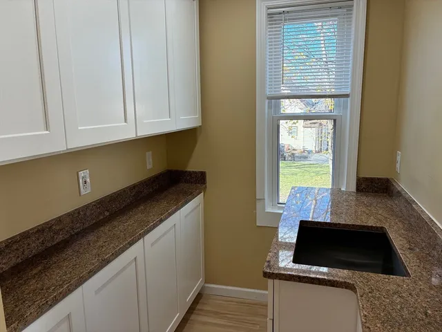 a kitchen with granite countertop a sink and a stove