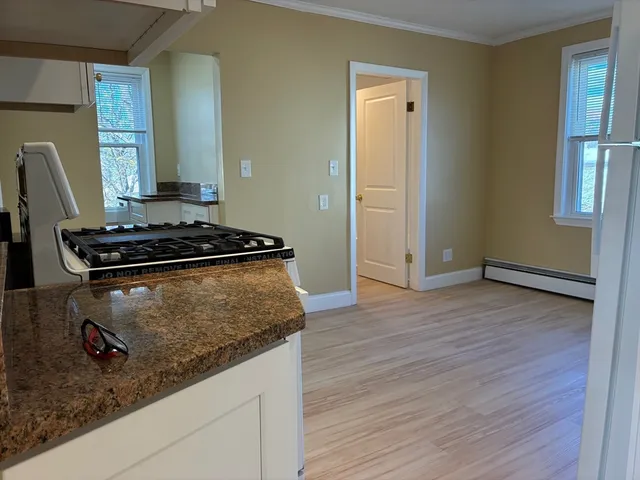 a kitchen with granite countertop a stove and a wooden floor