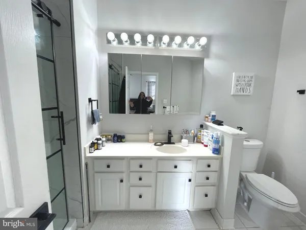 a spacious bathroom with a double vanity sink a mirror and a toilet