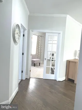 a view of a hallway with wooden floor and a window
