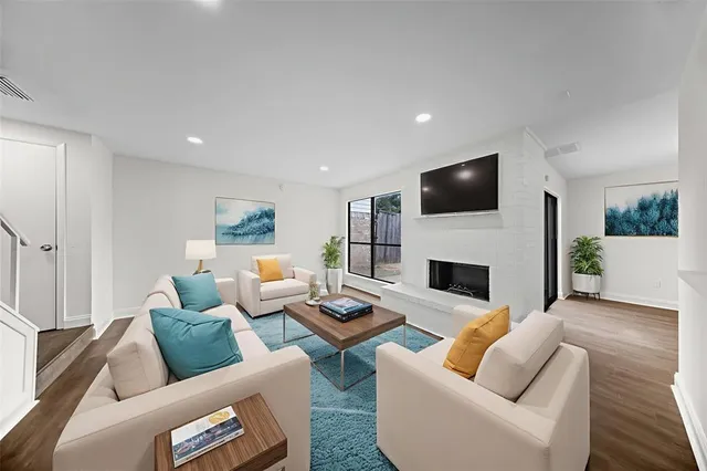 a living room with furniture a fireplace and a flat screen tv