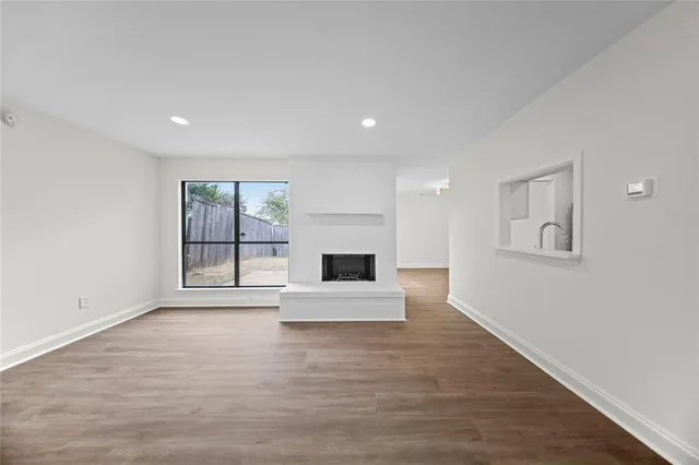 a view of an empty room with a fireplace and a window