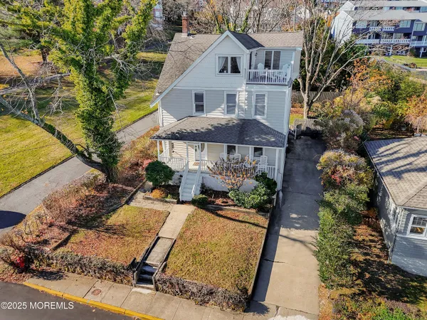 a view of a white house with a yard and sitting area