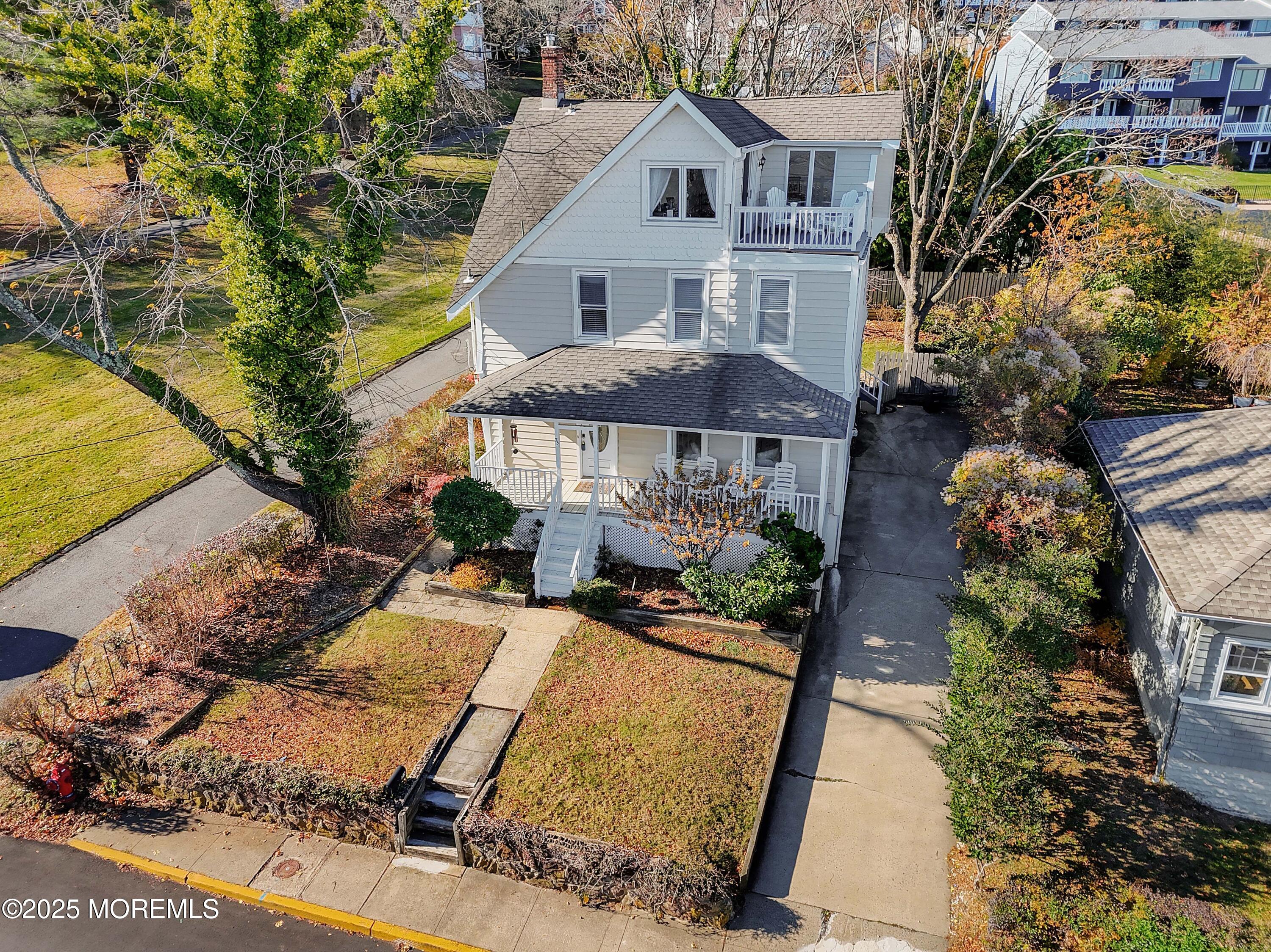 a view of a white house with a yard and sitting area