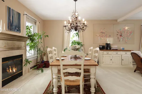 a dining room with furniture a fireplace and chandelier