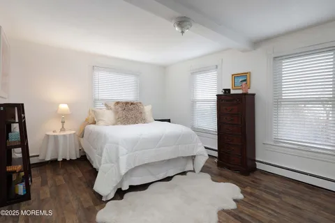 a bedroom with a bed and a flat tv screen on dresser