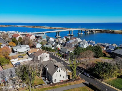 an aerial view of ocean and residential houses with outdoor space