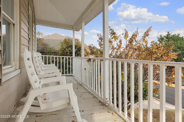 a view of a balcony with wooden floor and fence
