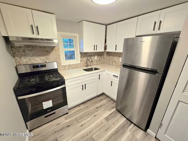 a kitchen with a stove refrigerator and a sink