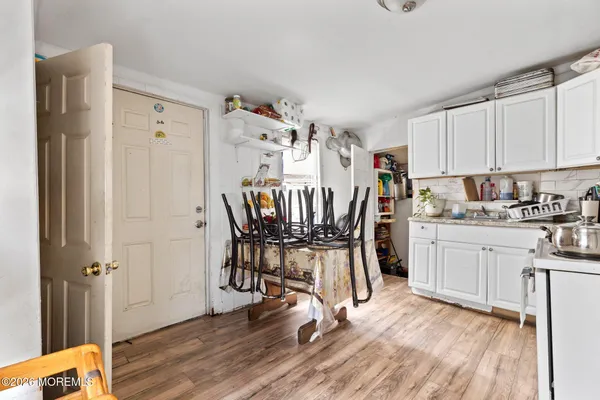 a kitchen with a refrigerator and white cabinets