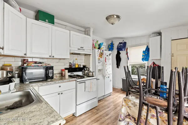a kitchen with stainless steel appliances a stove a sink cabinets and a dining table