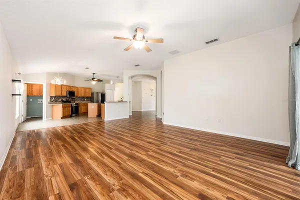 a view of a livingroom with wooden floor and a ceiling fan