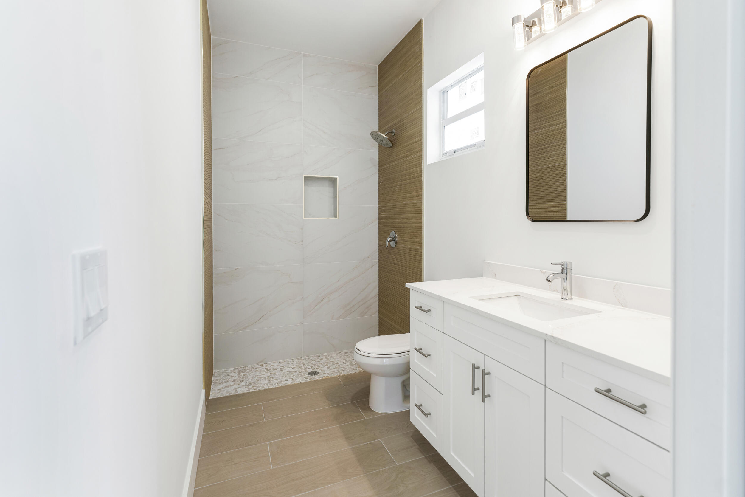 4641 Northview Drive Jupiter, FL 33458 - Photo 13 of 22 a bathroom with a toilet sink and mirror