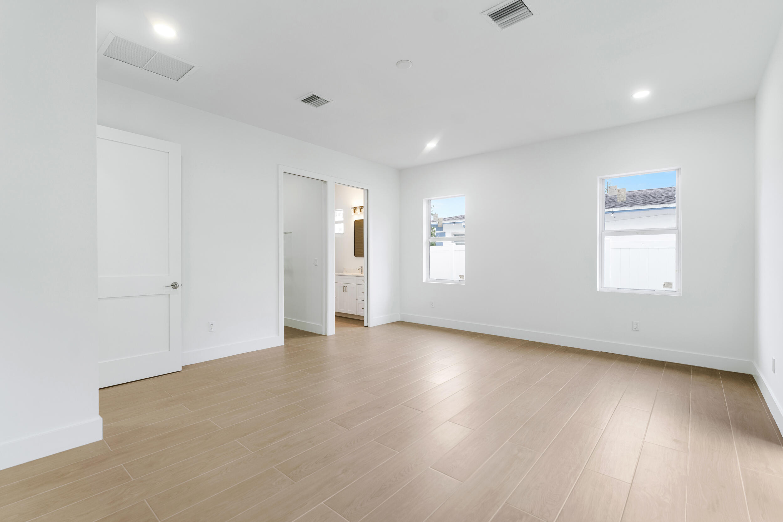 4641 Northview Drive Jupiter, FL 33458 - Photo 17 of 22 an empty room with wooden floor and windows