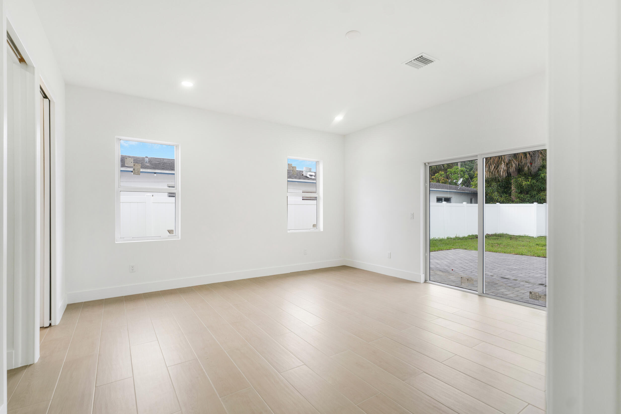 4641 Northview Drive Jupiter, FL 33458 - Photo 20 of 22 an empty room with wooden floor and windows