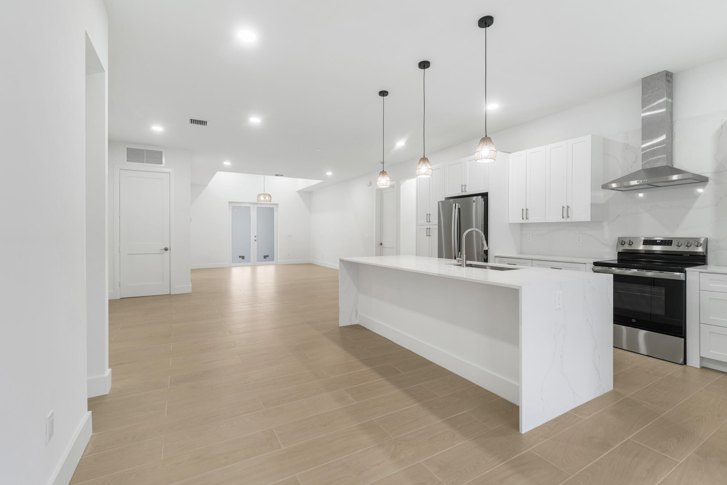 4641 Northview Drive Jupiter, FL 33458 - Photo 3 of 22 a large white kitchen with lots of counter space wooden floor and appliances