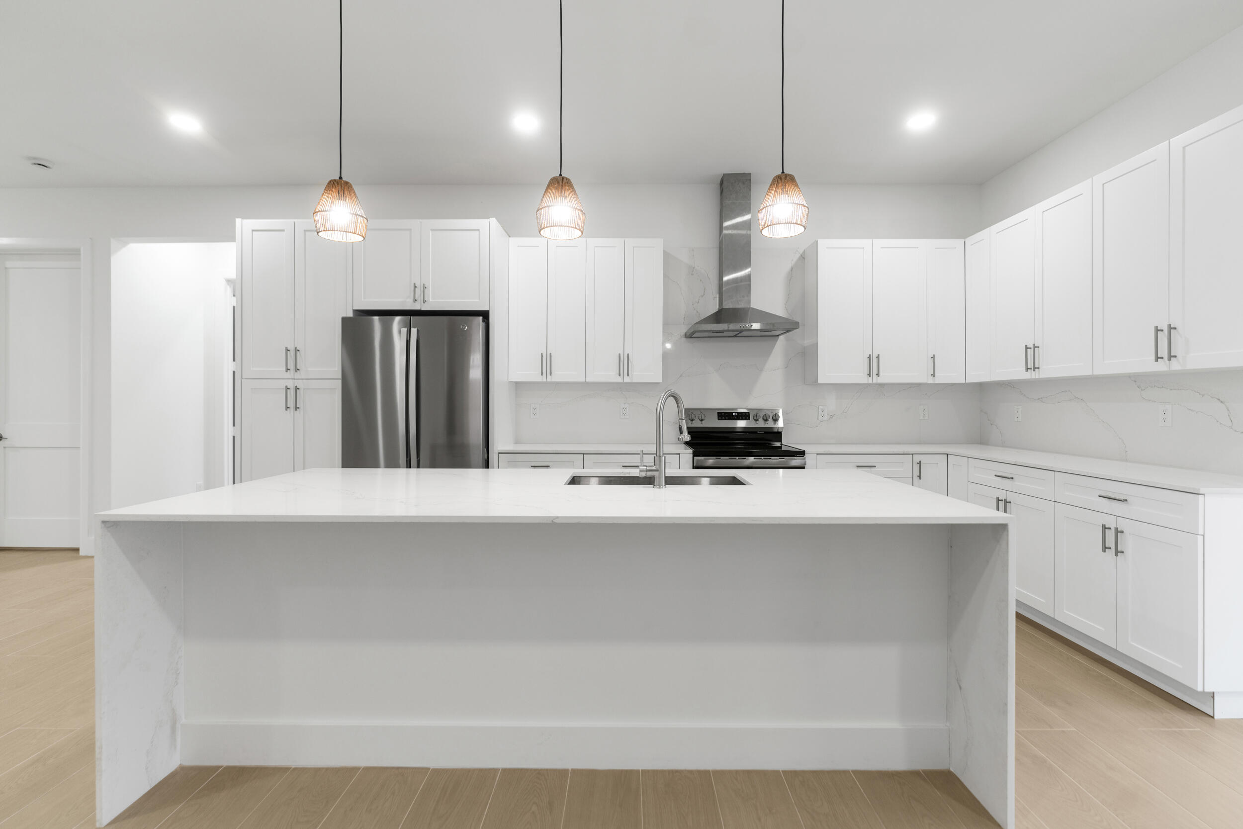 4641 Northview Drive Jupiter, FL 33458 - Photo 4 of 22 a kitchen with kitchen island a sink stainless steel appliances and white cabinets