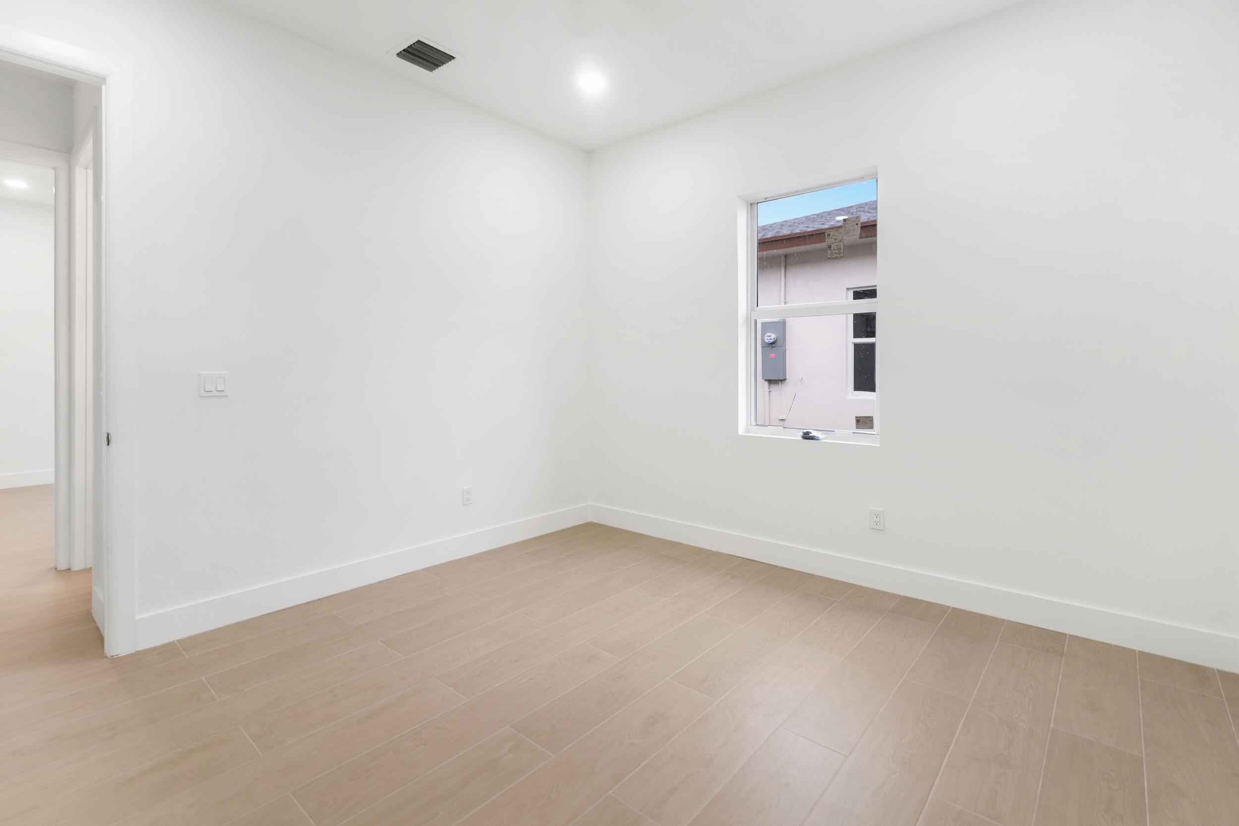 4641 Northview Drive Jupiter, FL 33458 - Photo 8 of 22 an empty room with a white cabinet and a window