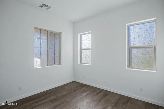a view of an empty room with wooden floor