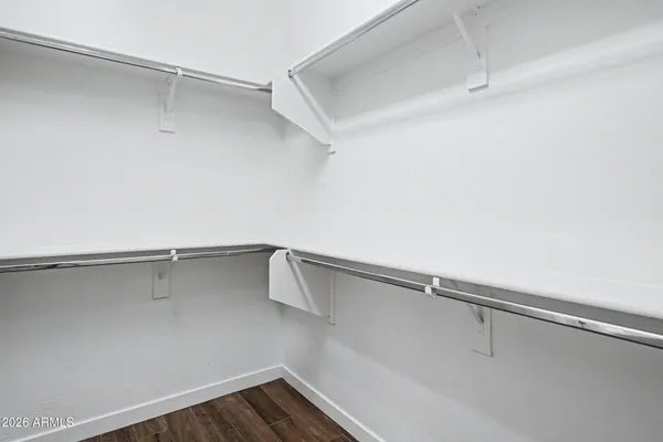 a kitchen with granite countertop stainless steel appliances white cabinets granite counter tops and a wooden floors