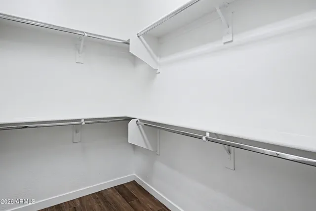 a kitchen with granite countertop stainless steel appliances white cabinets granite counter tops and a wooden floors