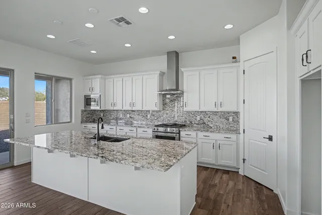 a kitchen with stainless steel appliances granite countertop a sink stove and cabinets