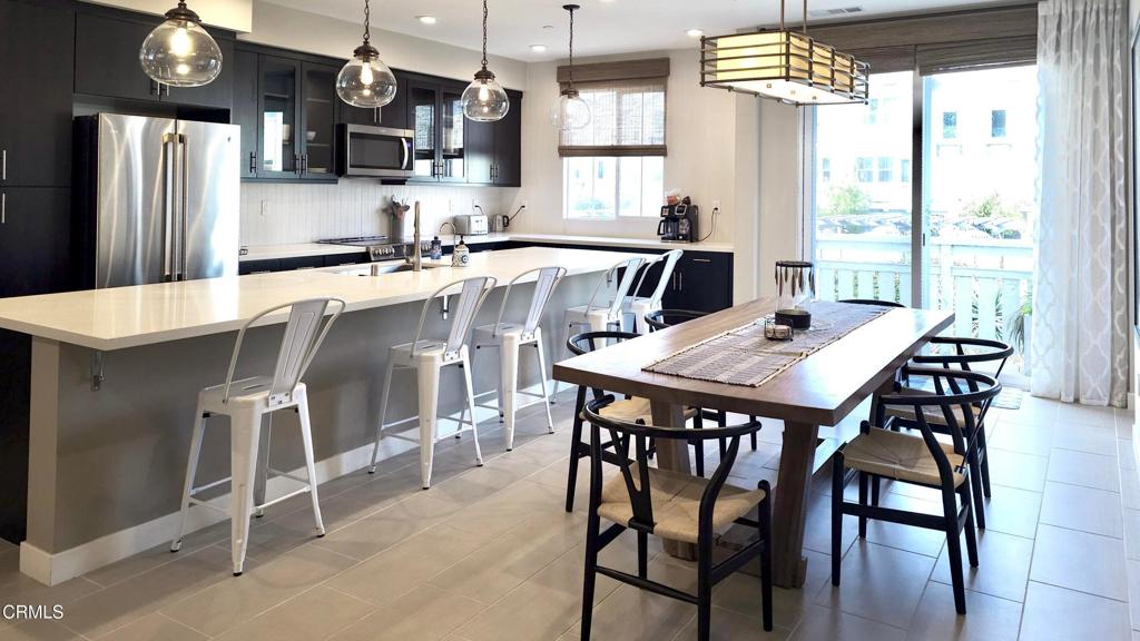5663 Surfrider Way, Unit 101 Goleta, CA 93117 - Photo 27 of 54 a kitchen with stainless steel appliances a table chairs sink and refrigerator