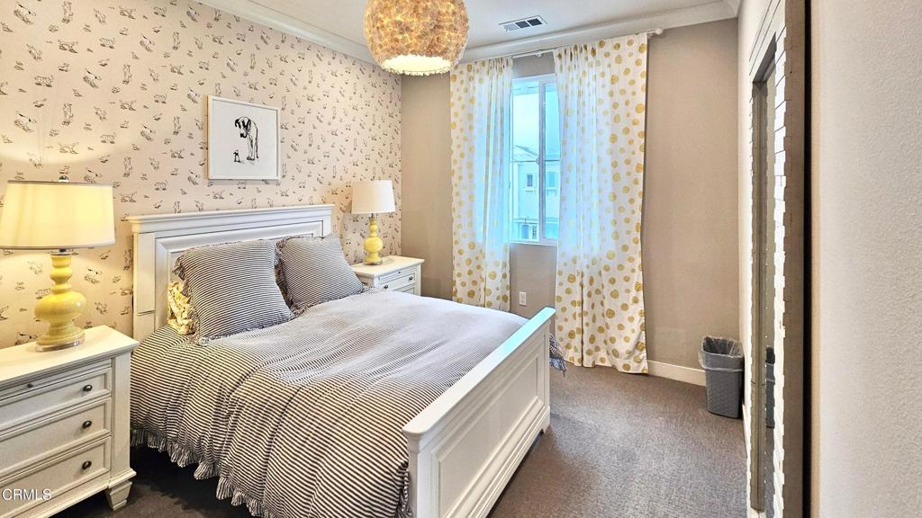 5663 Surfrider Way, Unit 101 Goleta, CA 93117 - Photo 39 of 54 a bedroom with a bed and a chandelier