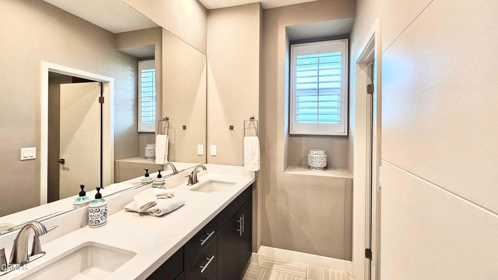 5663 Surfrider Way, Unit 101 Goleta, CA 93117 - Photo 42 of 54 a bathroom with a granite countertop sink and a mirror