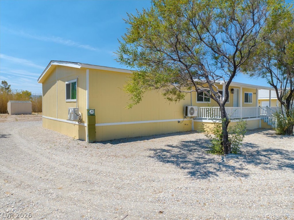 4081 Retread Road Pahrump, NV 89048 - Photo 77 of 98 A cheerful yellow residence with a welcoming porch and ample parking space.