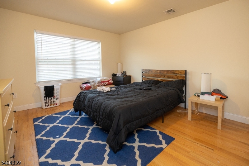 307 Pearl Street Elizabeth, NJ 07202 - Photo 10 of 13 a bedroom with a bed and wooden floor