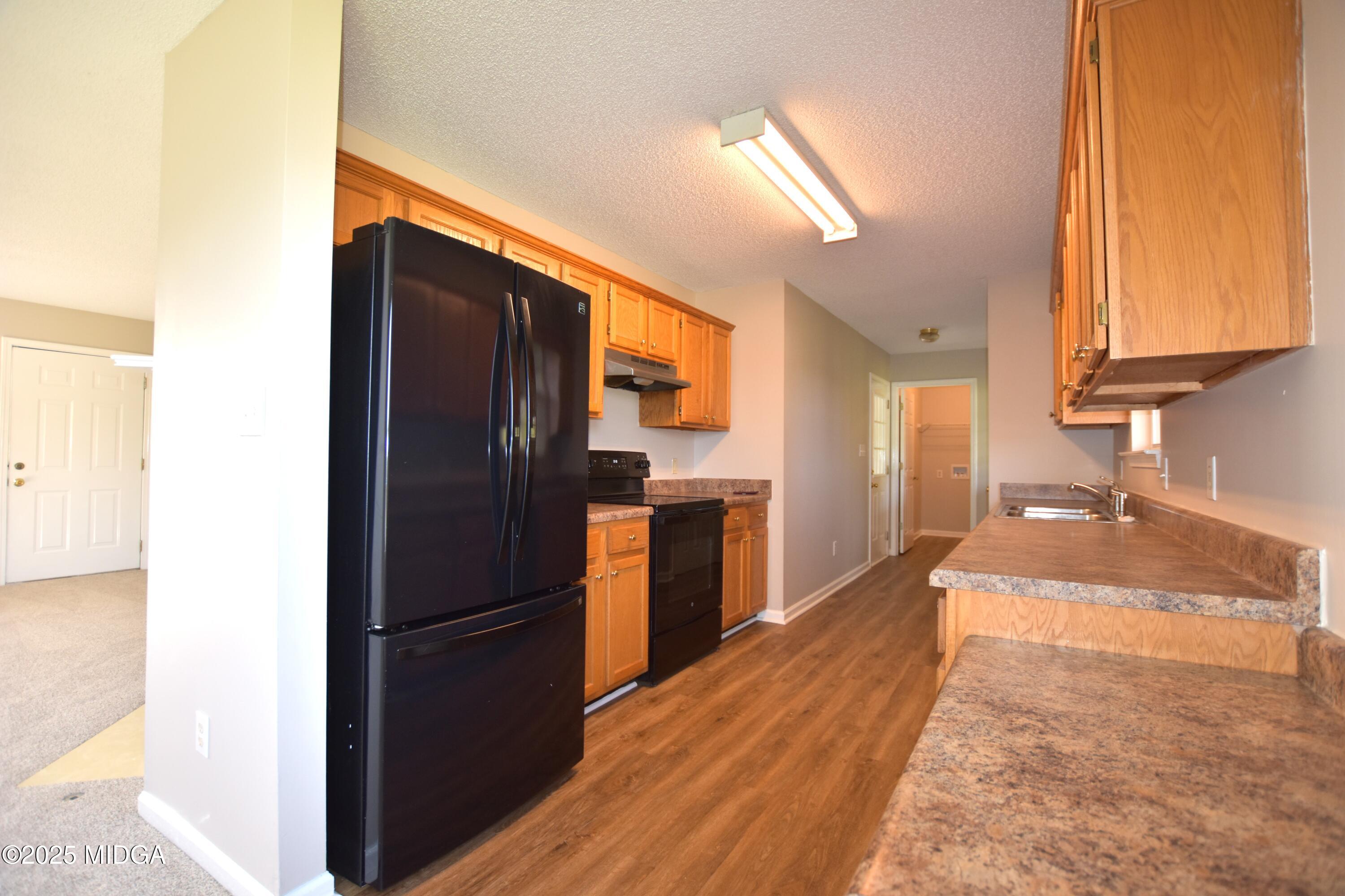 6550 Skipper Road Macon, GA 31216 - Photo 11 of 35 a kitchen with a refrigerator and a sink