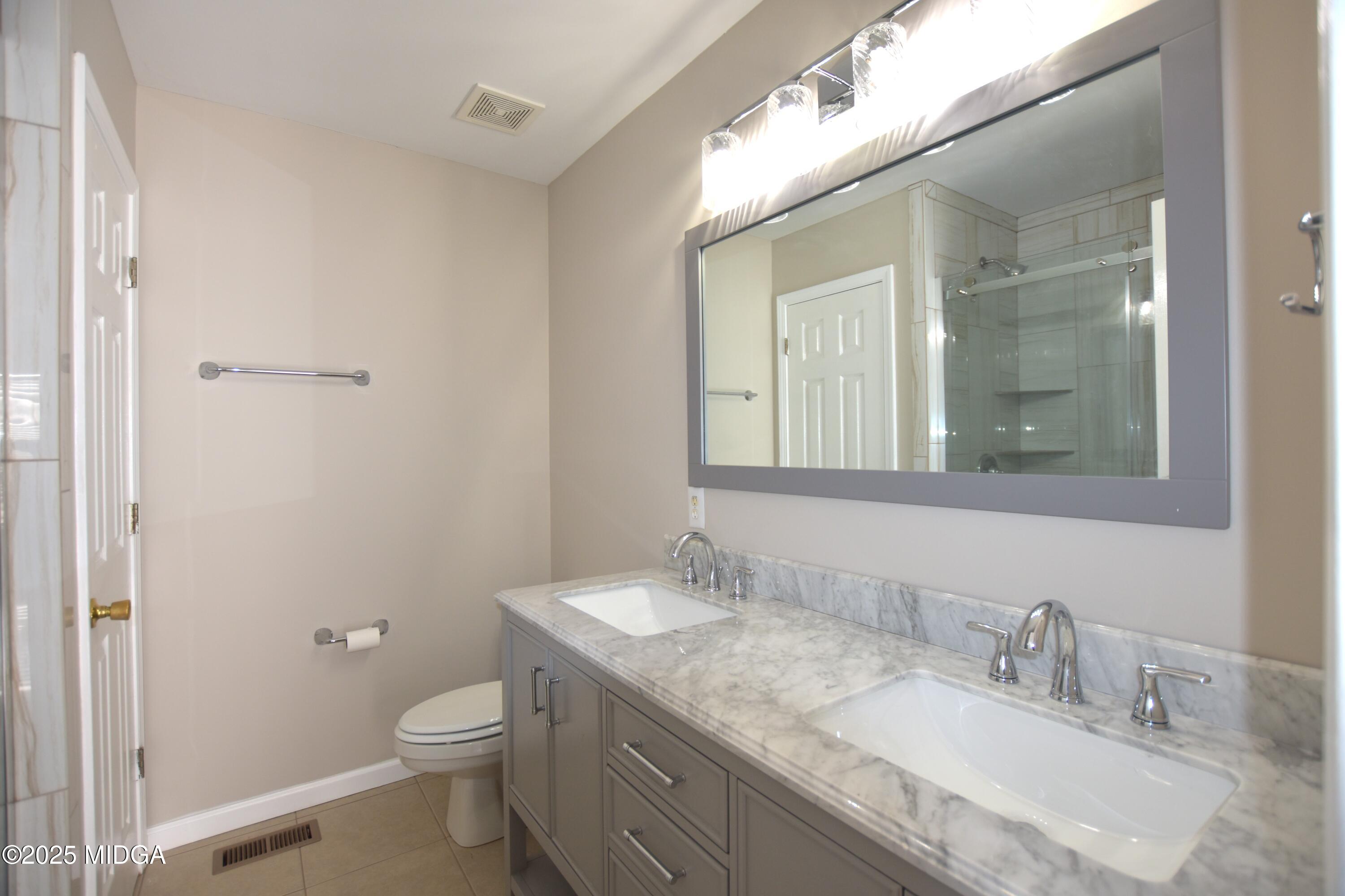 6550 Skipper Road Macon, GA 31216 - Photo 13 of 35 a bathroom with a granite countertop sink a toilet and a mirror